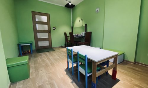Pokój do zajęć z dziećmi w mowiedobrze.pl: stolik, małe krzesła i lustro.
